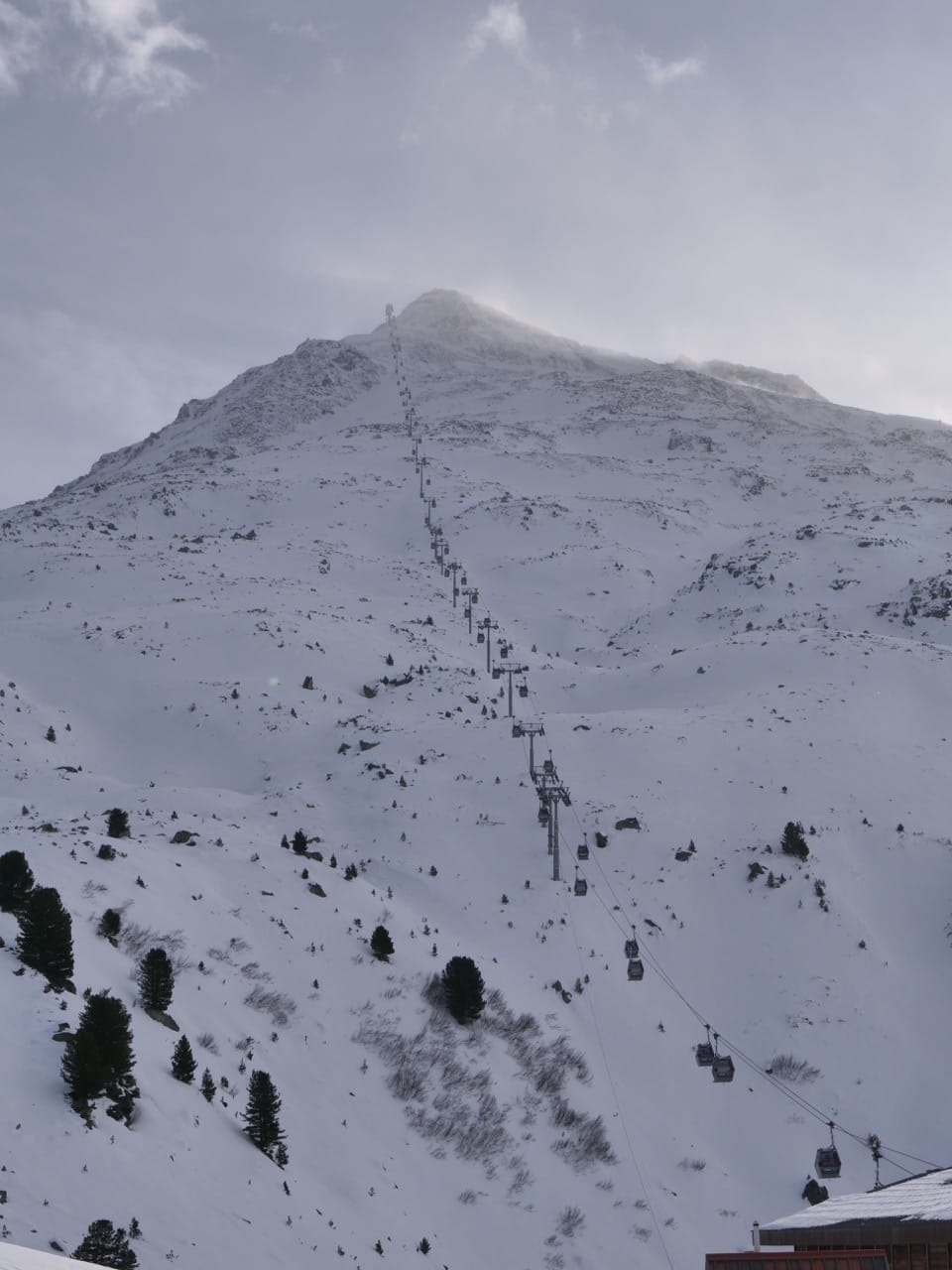 view from bottom of mountain looking up towards a ski life taking skiers to the summit